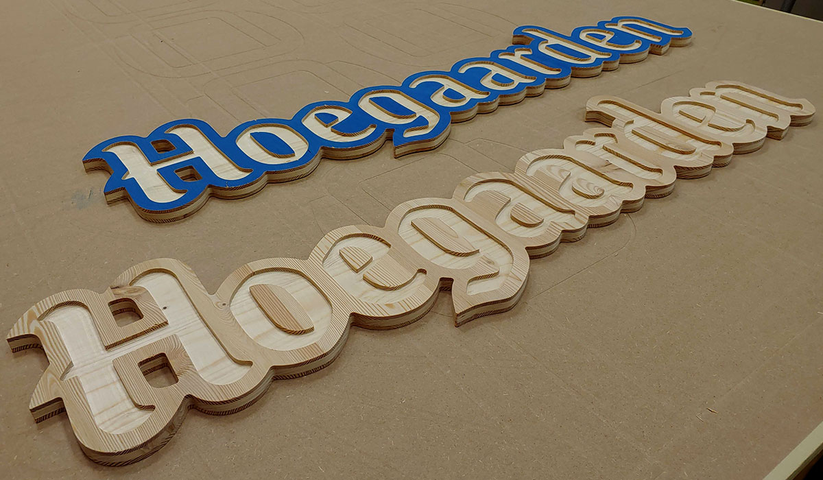 Vyfrézované interiérové 3D logo Hoegaarden z masivní modřínové biodesky.